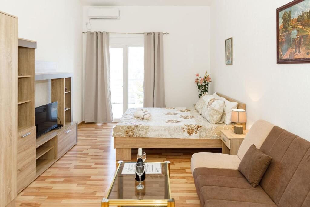 Apartment living area with sofa, television and dining table