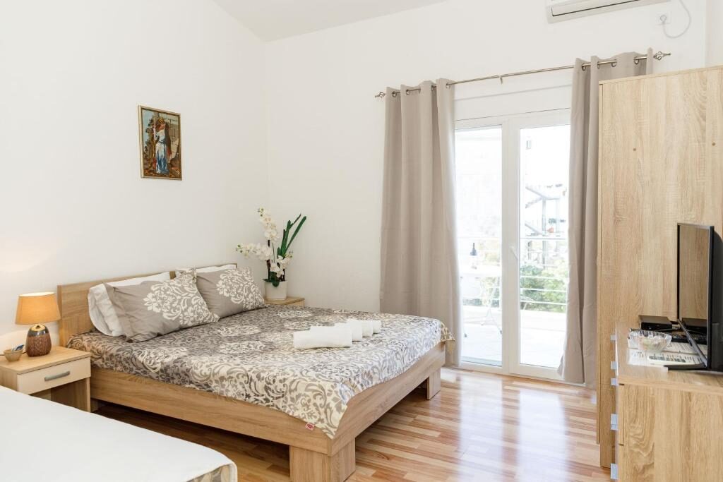 Apartment bedroom with wooden furniture and terrace access